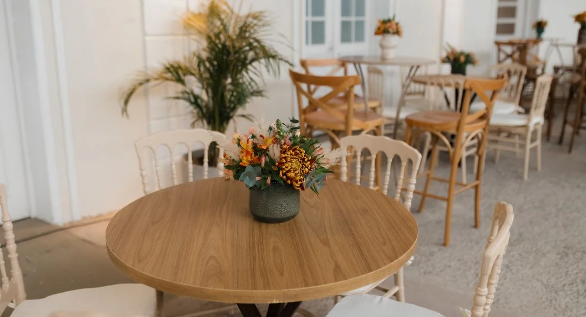 Warm and inviting indoor café setting with a round table and floral centerpiece, perfect for relaxation.