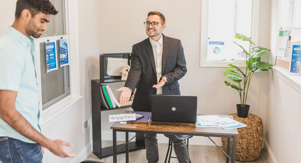 A professional business interaction in a modern office with a mortgage broker and client.