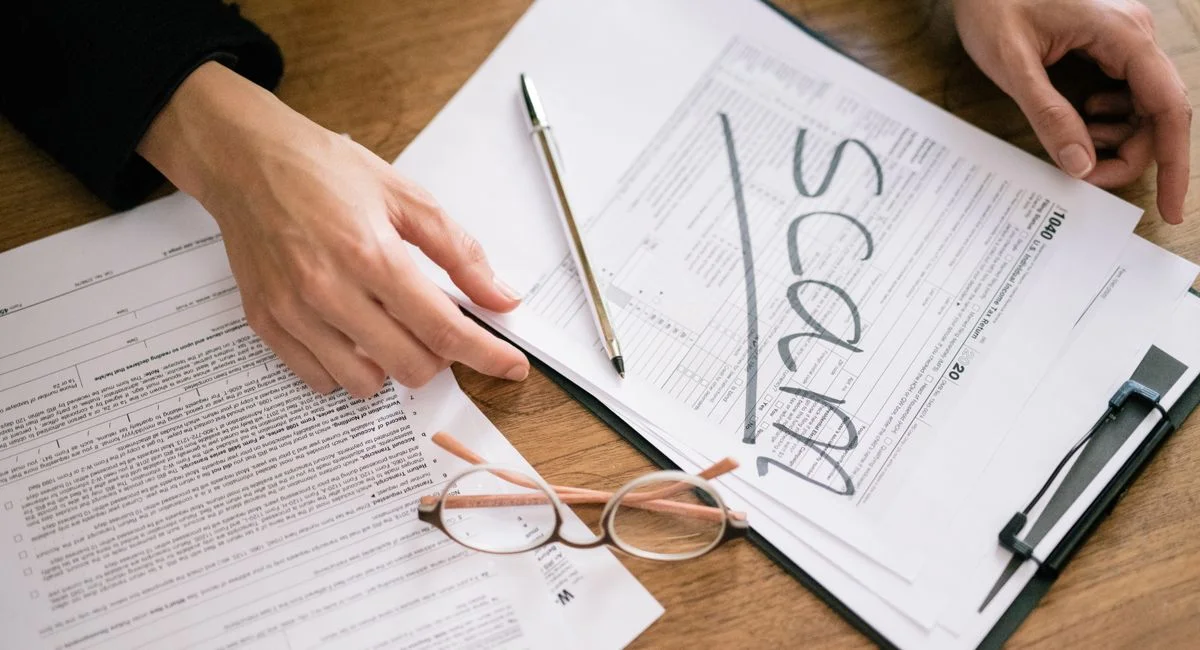 A close look at tax forms marked with scam, highlighting financial fraud risks.