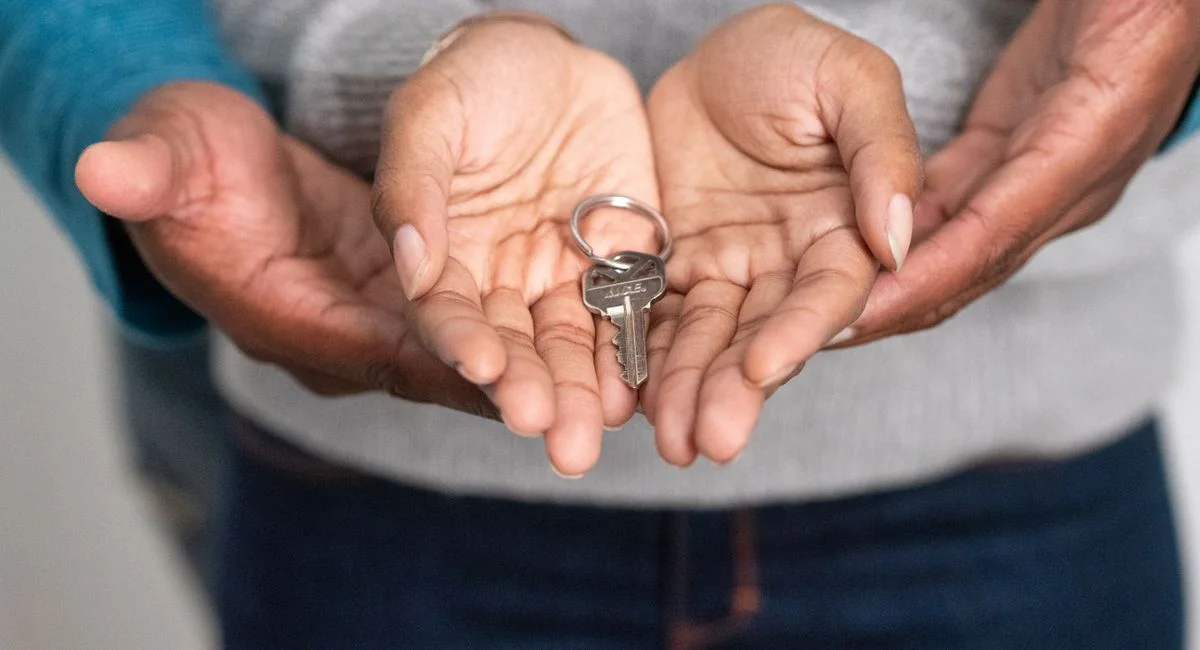 Close-up of hands holding a key, representing new homeownership and property investment.