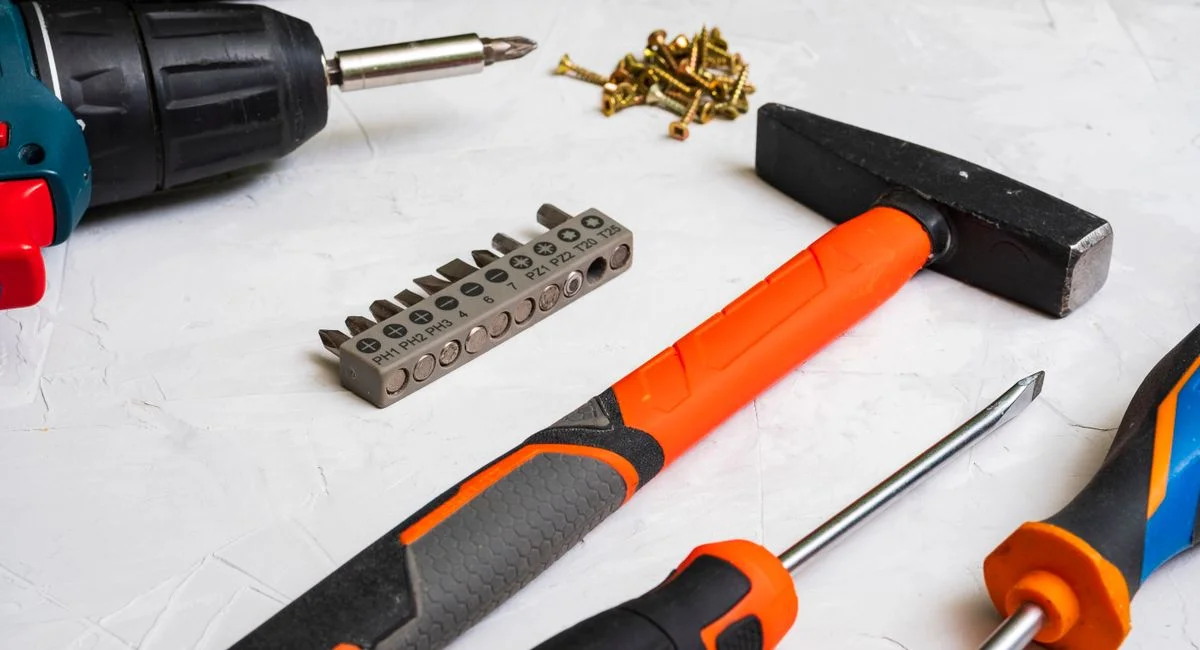 A selection of hand tools including a hammer, screwdriver, and drill bits for home improvement projects.