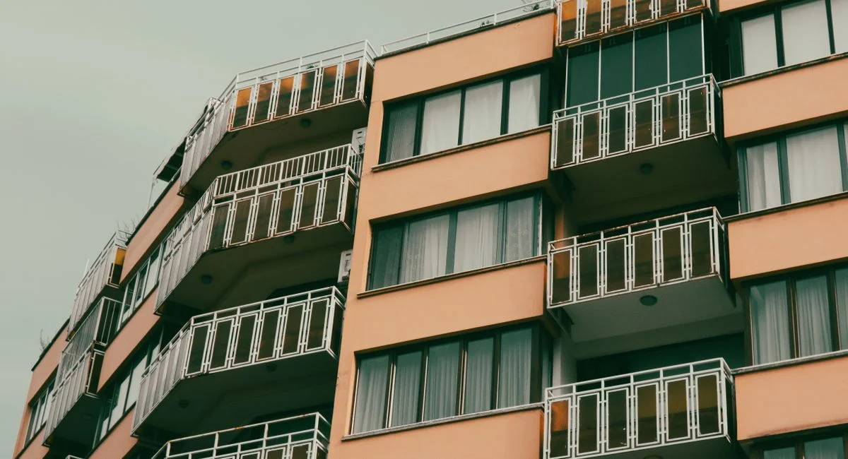 A contemporary apartment building with balconies in an urban setting.
