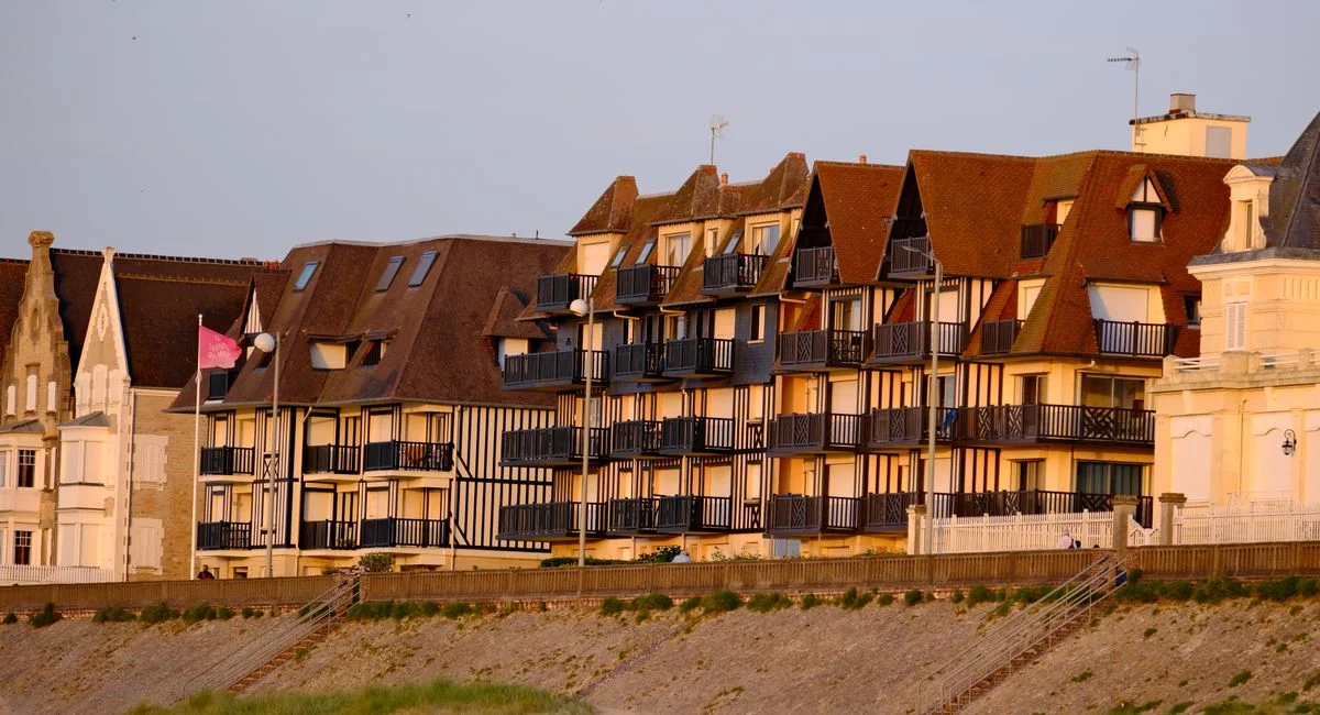 A picturesque view of charming seaside apartments in Cabourg, Normandie, France during sunset.