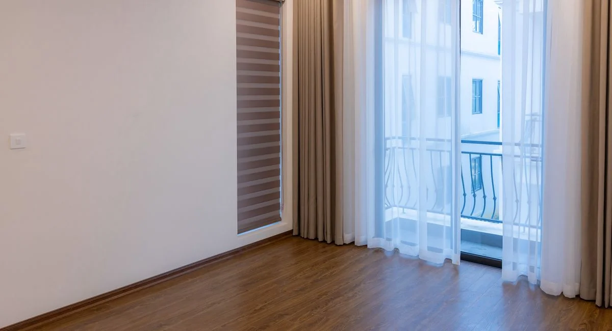 Bright modern room with wooden floor and large windows, ideal for real estate or interior design inspiration.
